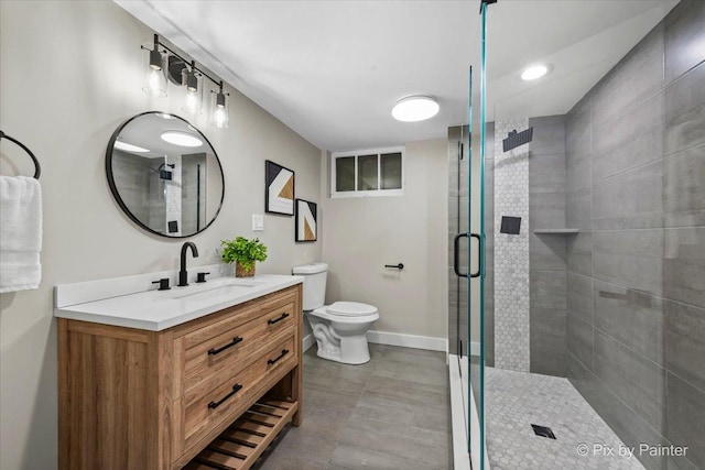 full bathroom featuring a stall shower, vanity, toilet, and baseboards