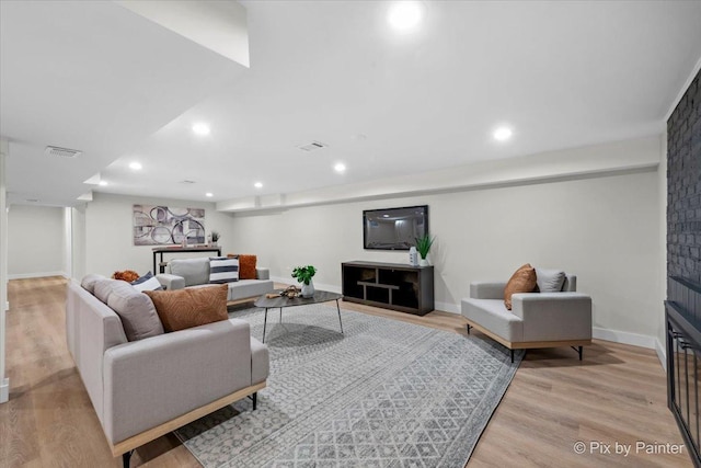 living room featuring a large fireplace and light hardwood / wood-style floors