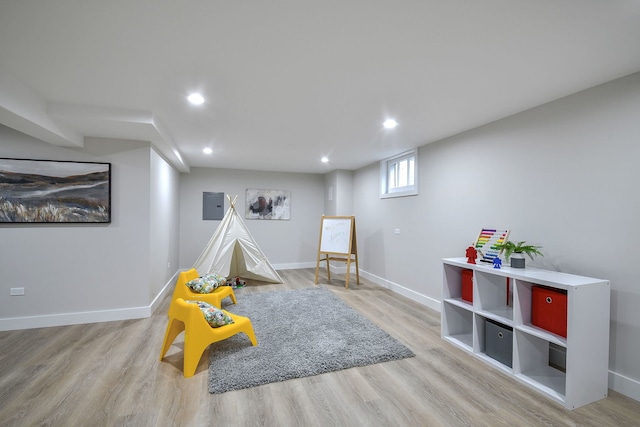 playroom with electric panel, baseboards, wood finished floors, and recessed lighting