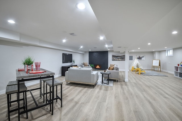 living room featuring light wood-style floors, recessed lighting, visible vents, and a fireplace