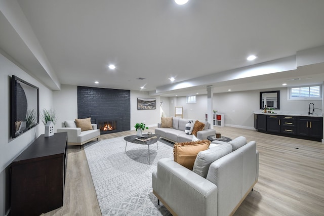 living room with a fireplace, recessed lighting, visible vents, light wood-style floors, and baseboards