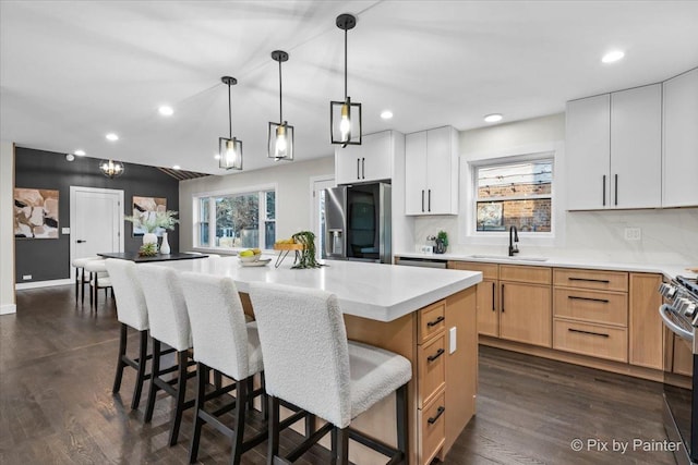 kitchen featuring appliances with stainless steel finishes, sink, a kitchen island, and white cabinets