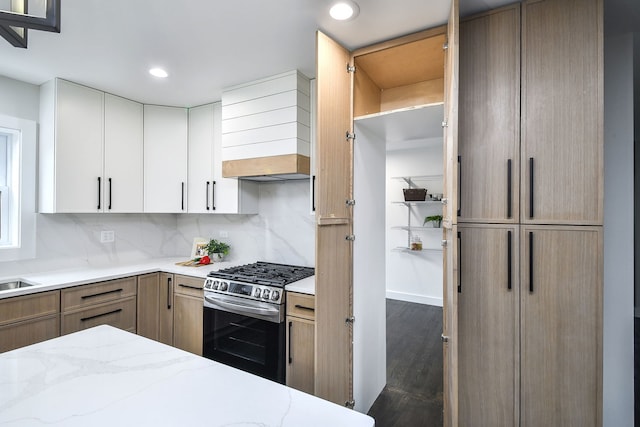 kitchen featuring wood finished floors, light stone countertops, stainless steel gas stove, tasteful backsplash, and custom range hood