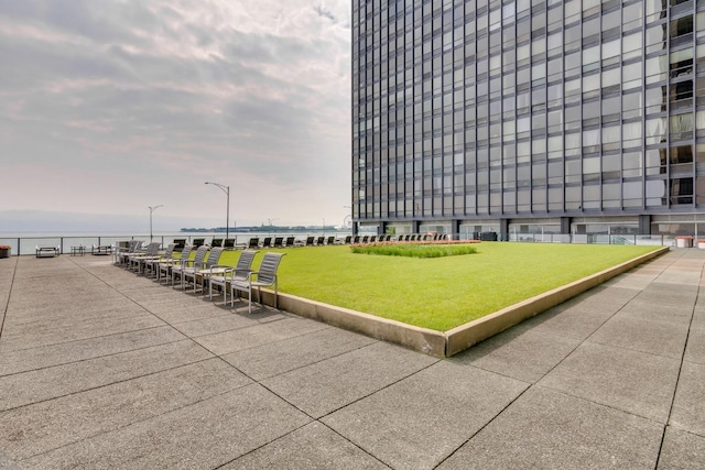 surrounding community featuring a lawn and a water view