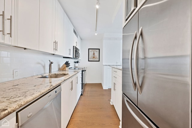 kitchen with white cabinetry, sink, backsplash, and stainless steel appliances