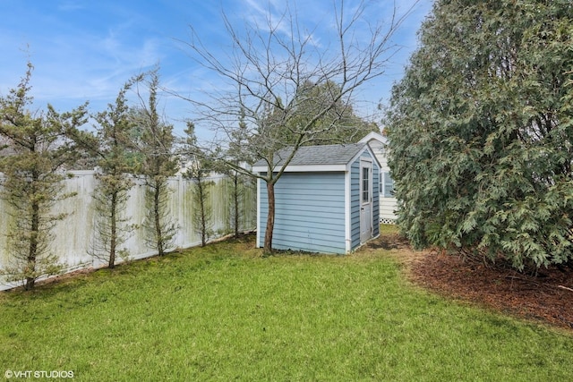 view of yard with an outbuilding, fence, and a storage shed