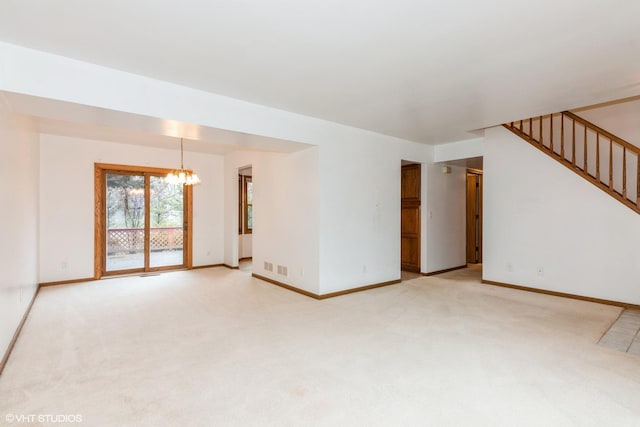 spare room featuring light carpet, an inviting chandelier, baseboards, and stairway