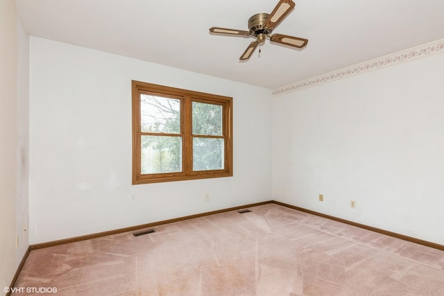 spare room featuring baseboards, visible vents, ceiling fan, and light colored carpet