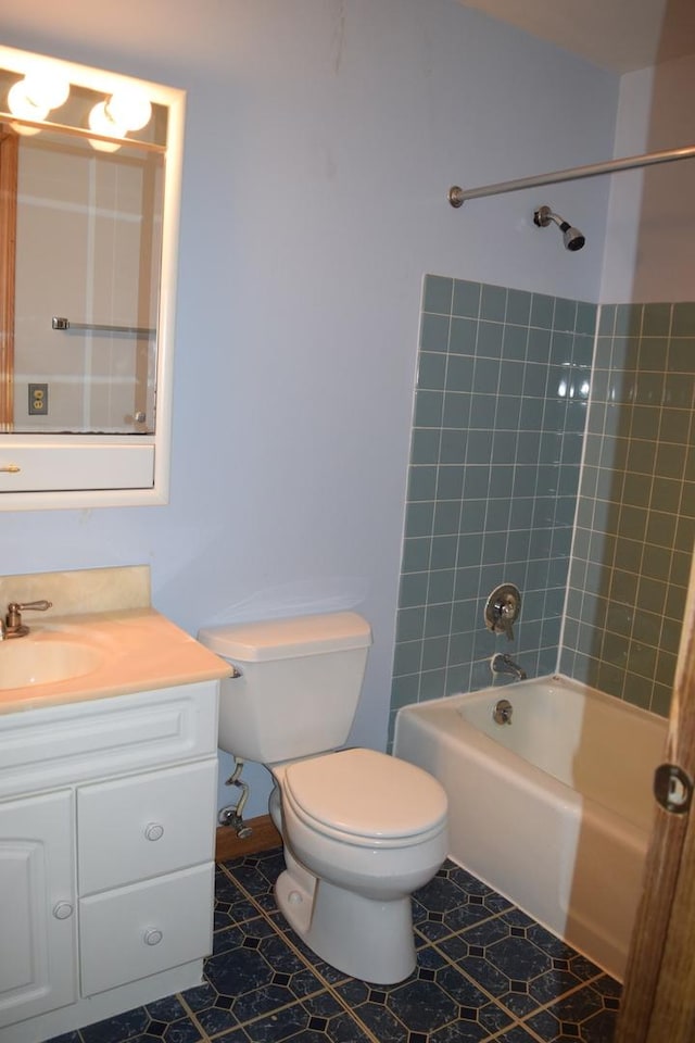 full bathroom featuring vanity, tiled shower / bath combo, tile patterned floors, and toilet