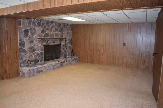 interior space with wooden walls, a fireplace, a paneled ceiling, and carpet floors