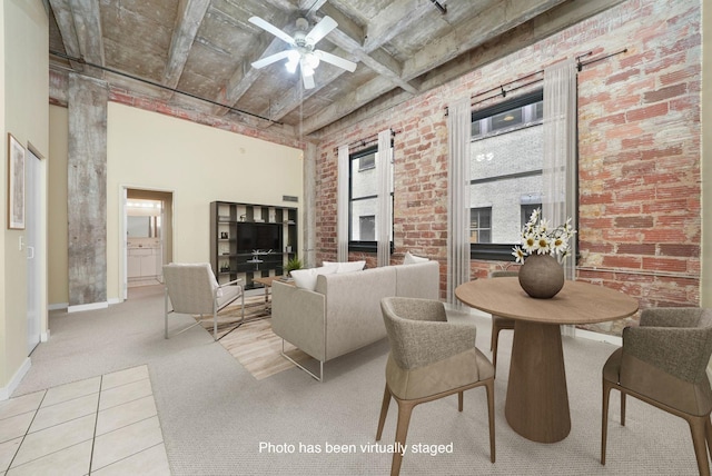 carpeted living room with ceiling fan, brick wall, and beam ceiling