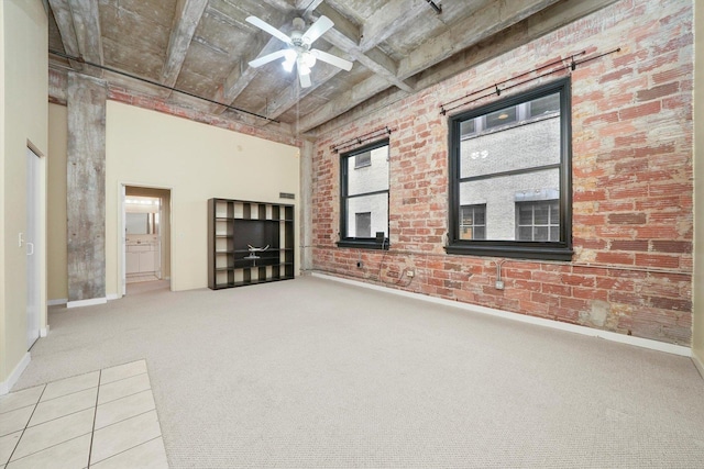 unfurnished living room with ceiling fan, carpet, brick wall, and beam ceiling