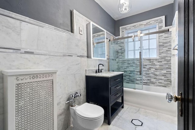 full bathroom with vanity, toilet, combined bath / shower with glass door, and tile walls