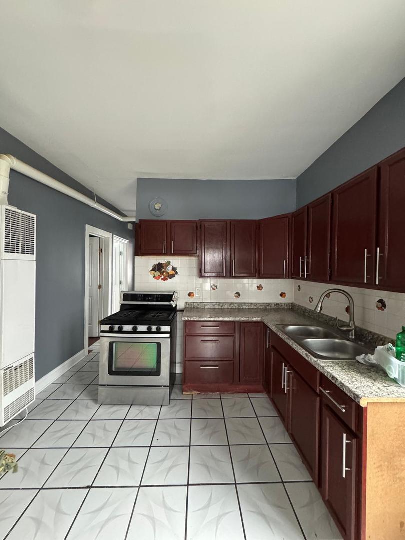 kitchen featuring sink, decorative backsplash, and stainless steel range with gas stovetop