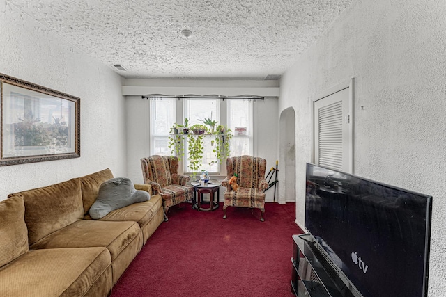 carpeted living room featuring a textured ceiling