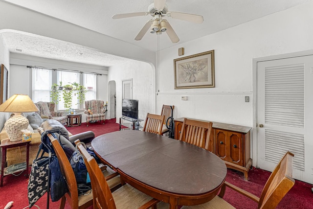 carpeted dining room featuring a textured ceiling and ceiling fan