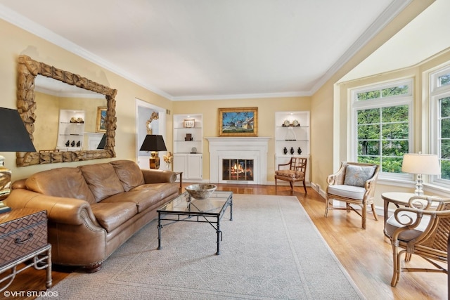 living room with ornamental molding, light hardwood / wood-style flooring, and built in shelves