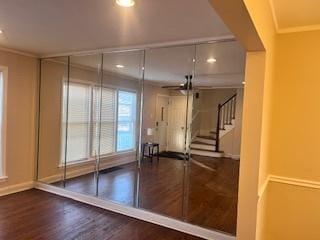 workout room featuring crown molding and hardwood / wood-style flooring