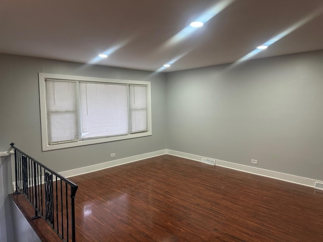 unfurnished room with dark hardwood / wood-style flooring