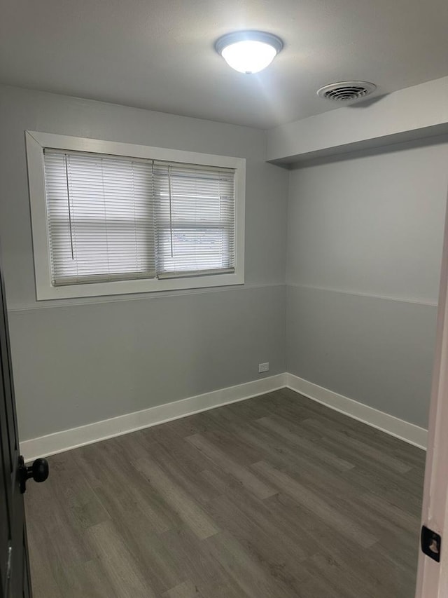 unfurnished room with dark hardwood / wood-style flooring