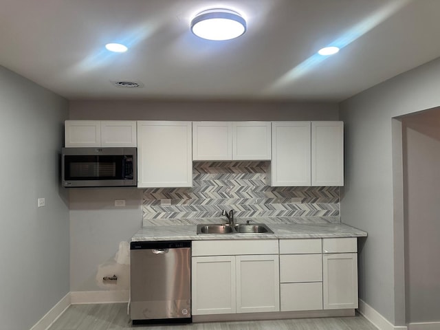 kitchen with white cabinetry, appliances with stainless steel finishes, and sink