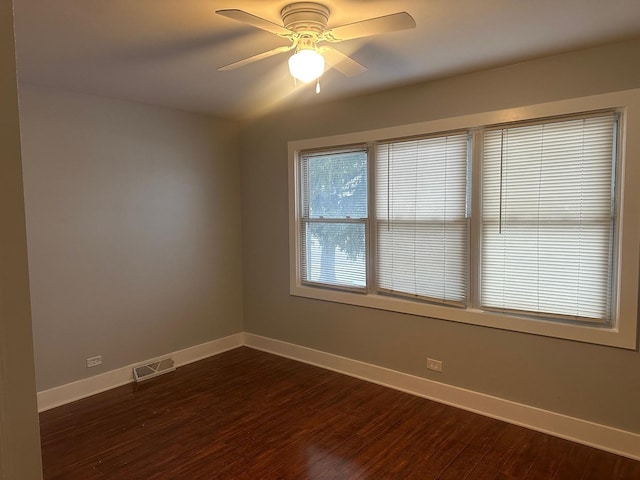 unfurnished room with ceiling fan and dark hardwood / wood-style flooring