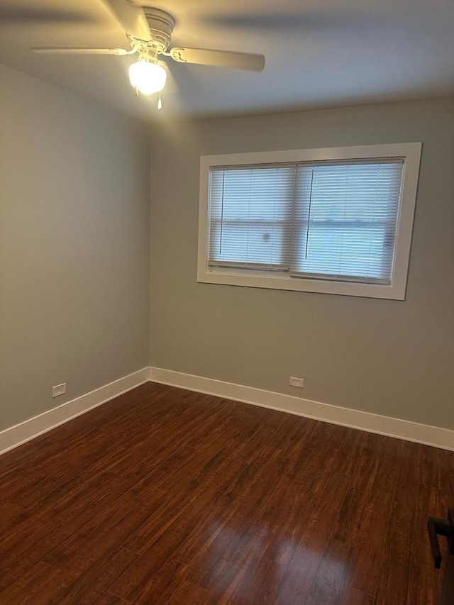 empty room featuring dark hardwood / wood-style flooring, ceiling fan, and plenty of natural light