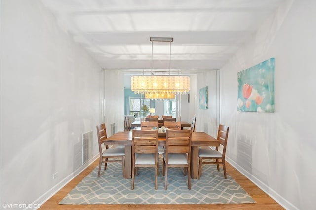 dining room with hardwood / wood-style flooring and a notable chandelier