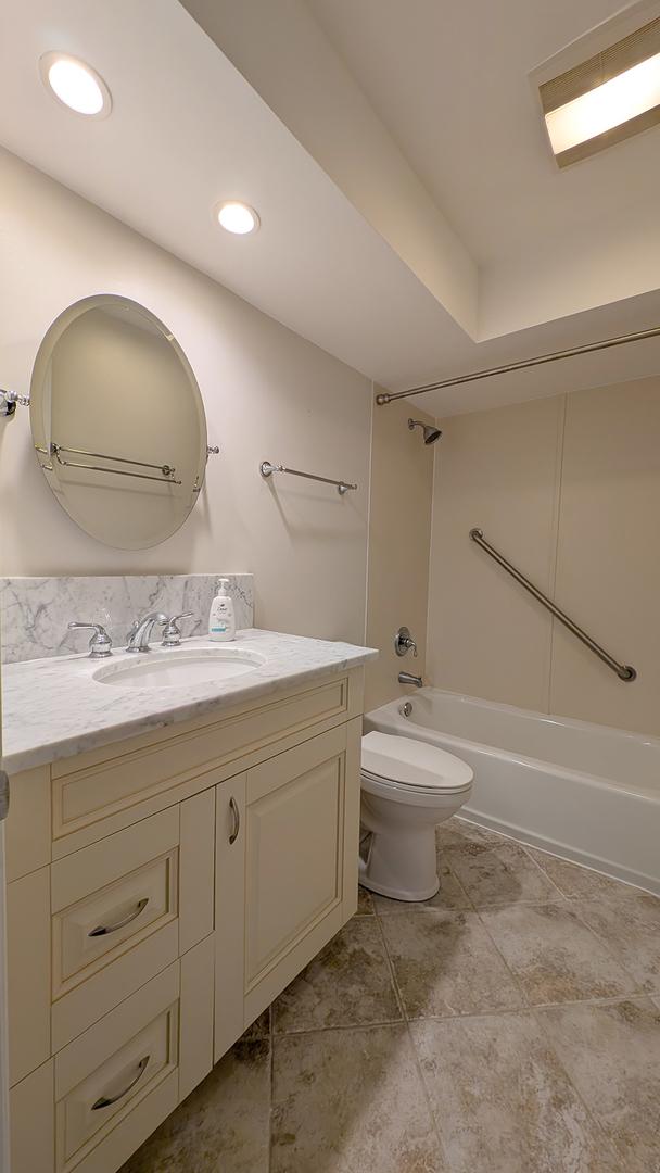 full bathroom featuring toilet, vanity, and bathtub / shower combination