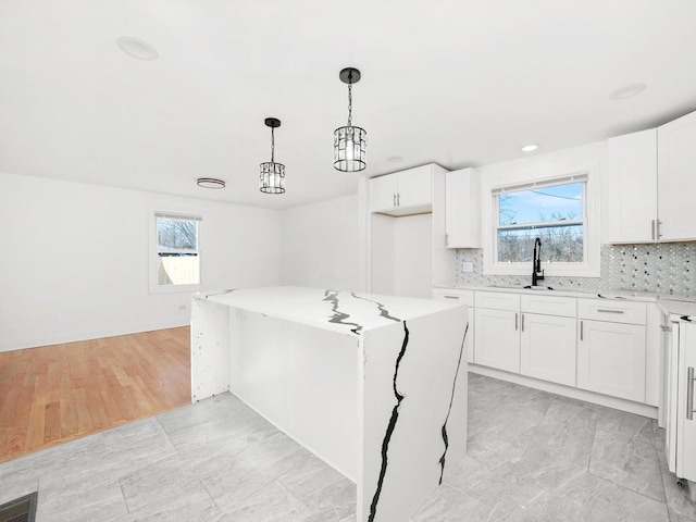 kitchen featuring sink, a center island, and white cabinets