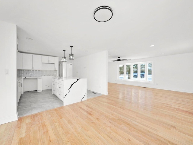 unfurnished living room with ceiling fan and light hardwood / wood-style floors