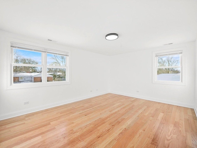 unfurnished room with plenty of natural light and light hardwood / wood-style floors