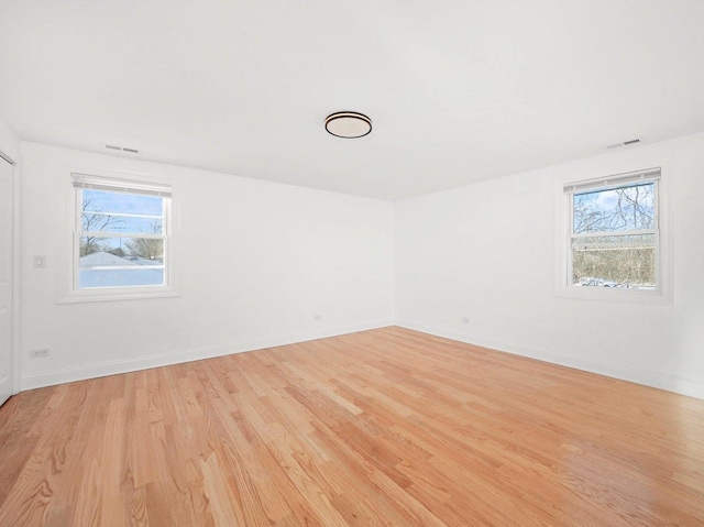 unfurnished room featuring a healthy amount of sunlight and light wood-type flooring