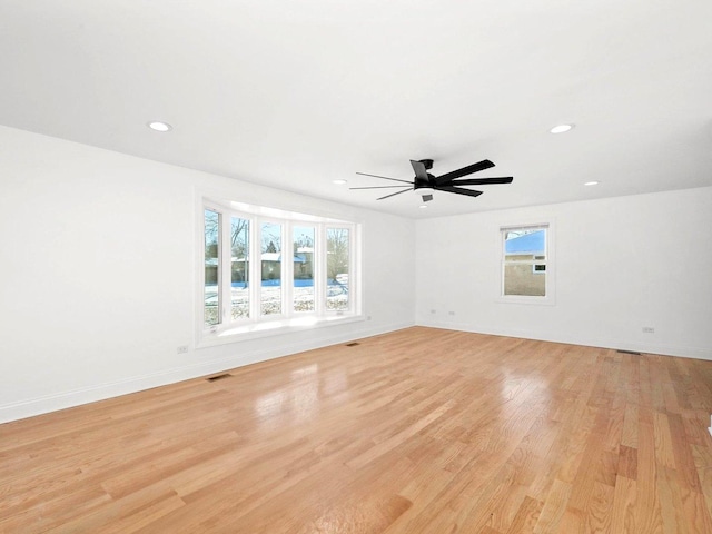 empty room featuring a wealth of natural light, light hardwood / wood-style floors, and ceiling fan