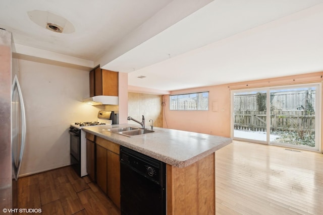 kitchen with sink, light hardwood / wood-style flooring, black dishwasher, range with gas cooktop, and kitchen peninsula