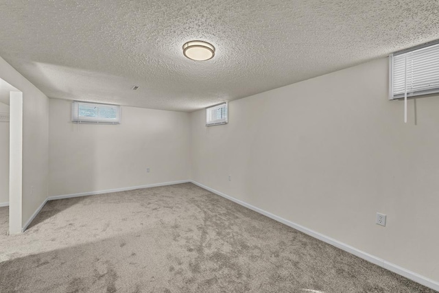 basement with an AC wall unit, carpet floors, and a textured ceiling