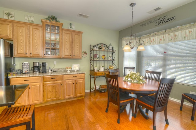 dining space featuring an inviting chandelier and light hardwood / wood-style flooring