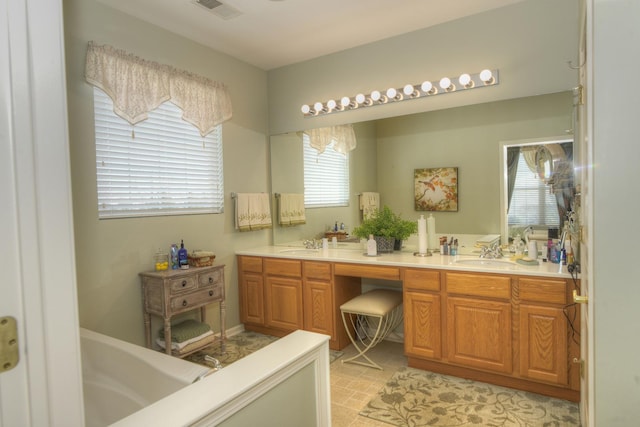 bathroom featuring vanity, a bathing tub, and a healthy amount of sunlight