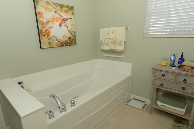 bathroom with a washtub and tile patterned floors