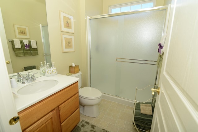 bathroom with vanity, a shower with door, and toilet