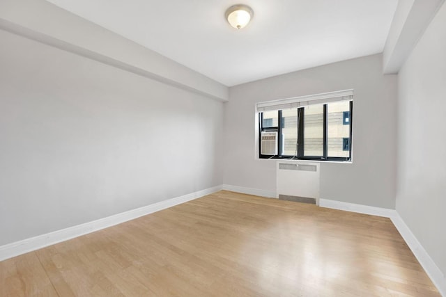 empty room featuring light hardwood / wood-style flooring and radiator heating unit