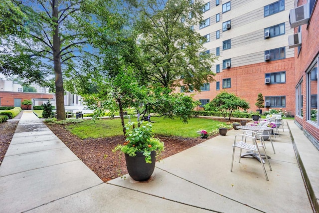 view of property's community with a lawn and a patio area