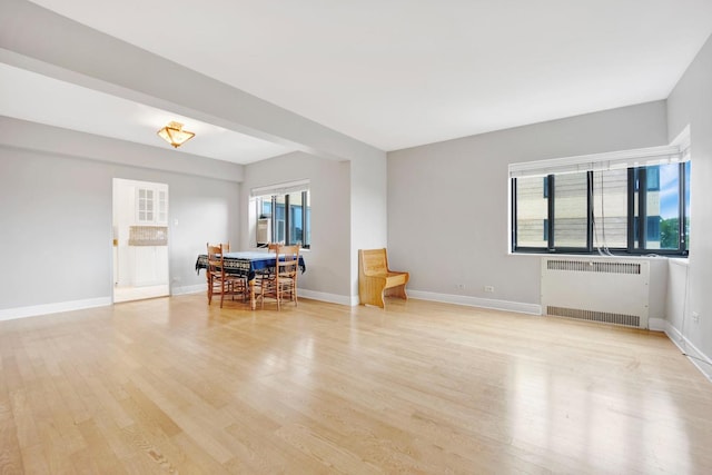 living room featuring radiator heating unit and light wood-type flooring