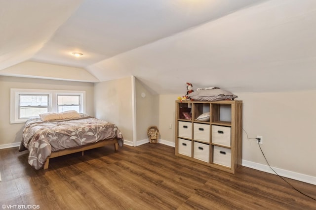 bedroom with lofted ceiling and dark hardwood / wood-style floors