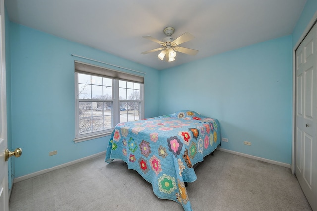 carpeted bedroom with ceiling fan and a closet