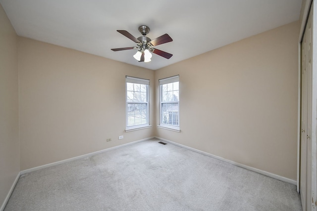 empty room featuring light colored carpet and ceiling fan