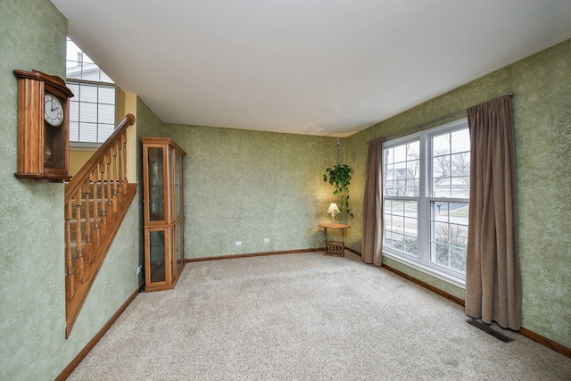 unfurnished living room featuring plenty of natural light and carpet floors