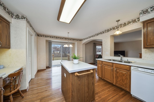 kitchen featuring sink, hanging light fixtures, white dishwasher, a kitchen island, and hardwood / wood-style floors