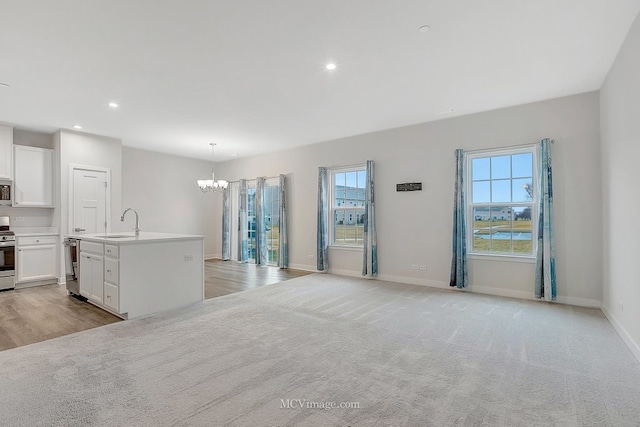 interior space featuring sink, light colored carpet, and a chandelier