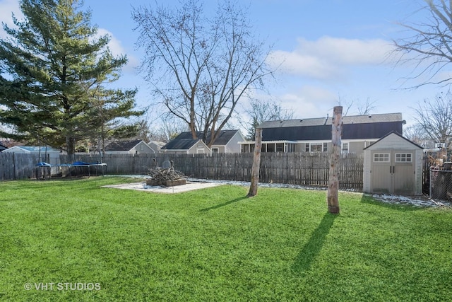 view of yard featuring a trampoline, a patio area, and a shed